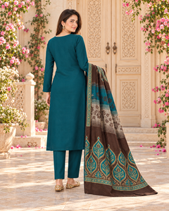 AI suggested plain-back styling view of a peacock teal suit beside carved cream doors.
